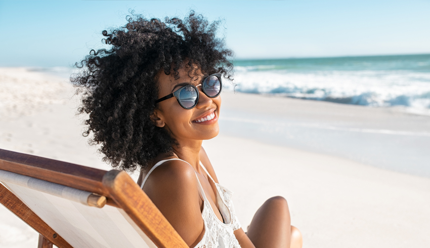 an african-american woman on the beach smiling